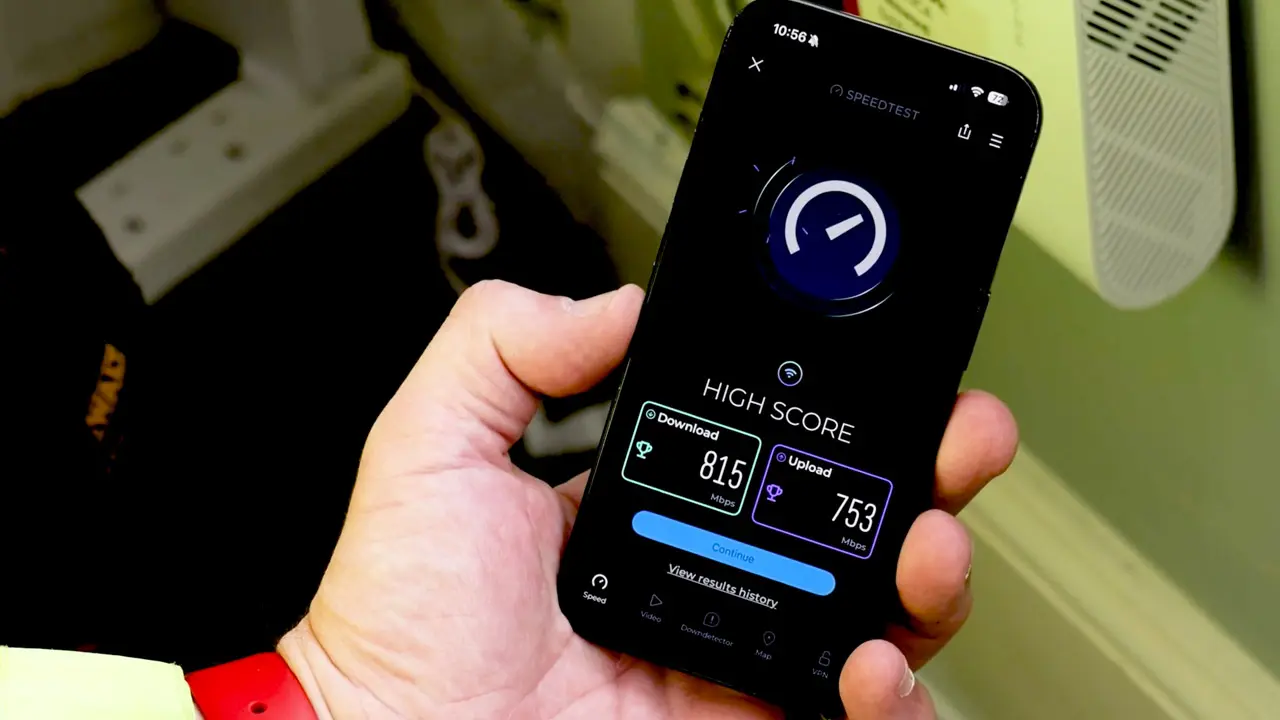 hand holding a smart phone with broadband speed test app showing a high score